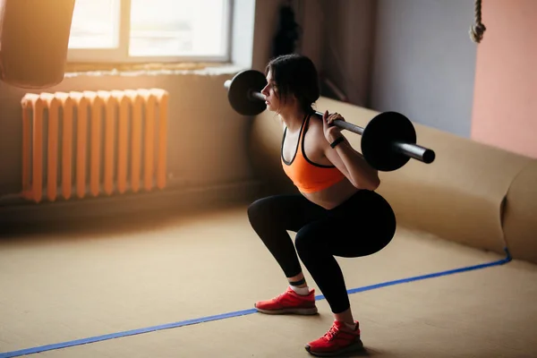 Antrenorul de fitness al spectacolelor franceze este un ghemuit cu o barbă în sala de sport. Îmbrăcat într-un top luminos și jambiere negre — Fotografie, imagine de stoc