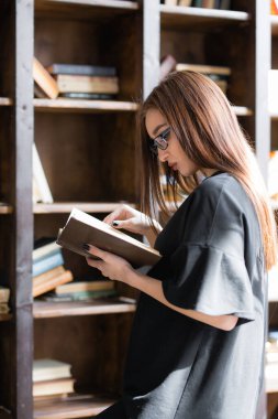 Zeki öğrenci üniversitede bir sınav için hazırlanıyor ve hazırlanmak için malzeme arıyor. Üniversitenin büyük kütüphanesi.