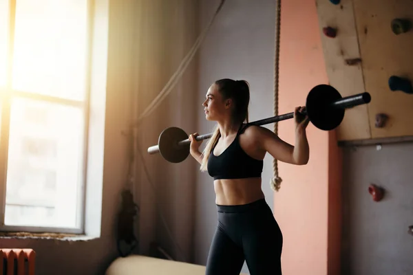 Treinador de fitness fazendo exercícios esportivos para músculos das costas usando uma barra no ginásio — Fotografia de Stock