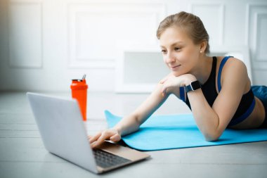 Beden eğitimi hocası, bir dizüstü bilgisayardaki insanlar için çevrimiçi bir ders sırasında egzersizlere ara verdi. Evde spor yapıyorum.