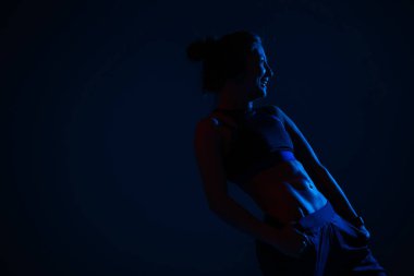 Neon mavi ışıklandırma, koyu mavi arka planda dışsal obdominal kas modelini gösterir..