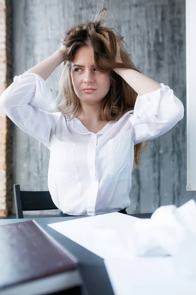 Empleado de la empresa está estresado debido a la cantidad de trabajo. Chica voltea su cabello y mira hacia otro lado, sin saber qué hacer . — Foto de Stock