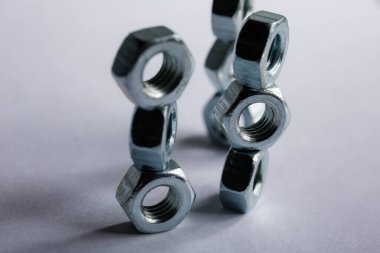 Metal fındıklar beyaz arka plana düzgünce serilmiş. Macro vuruldu. İnşaat ve onarım konsepti