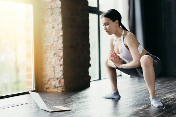 Asiatic fata face plie squats. Lecție de balet online. Întinderea într-un studio luminos cu ferestre mari — Fotografie, imagine de stoc