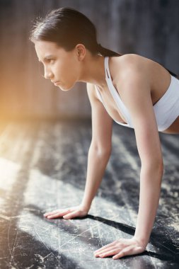 Bir fitness stüdyosunda Asyalı bir sporcu kollarını düz bir şekilde zemine koyuyor. Tüm vücudun kaslarını güçlendirir..