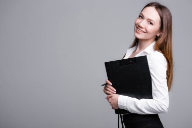 Elinde tabletle gri arka planda gülümseyen kadın avukat. Güzel kızıl saçlı avukat kız.