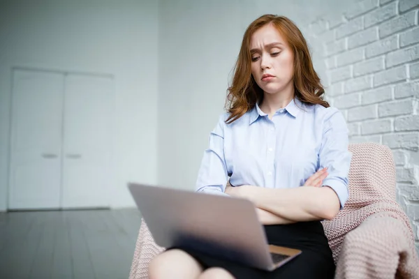 Chica de negocios mira desagradablemente a la pantalla del ordenador portátil y dobló los brazos sobre su pecho, pensando en otras acciones . — Foto de Stock