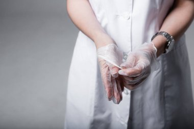 Yakın plan. Şeffaf koruyucu eldivenler giymiş kadın bir doktorun elleri. Coronavirus enfeksiyon koruması