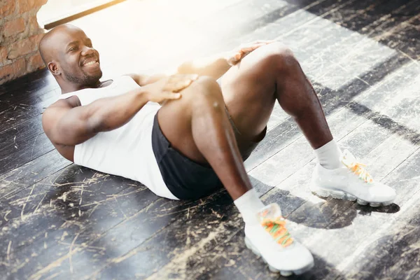Vista superior de un entrenador de Pilates de piel oscura muscular haciendo ejercicios abdominales y abdominales . —  Fotos de Stock