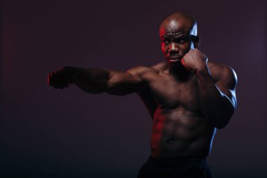 Profesyonel siyah boksör boksörü ve neon ışıklı güreş müsabakasından önce egzersiz yapıyor.