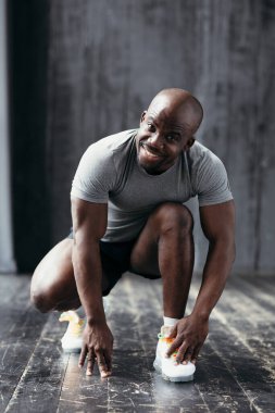 Beyaz kros yapan güçlü ve kaslı gülümseyen Afrikalı Amerikalı spor yaptıktan sonra kameraya baktı..