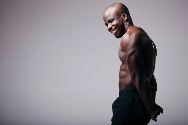 Muscular Africano americano fisiculturista mostrando tríceps. Isolado em fundo cinza — Fotografia de Stock