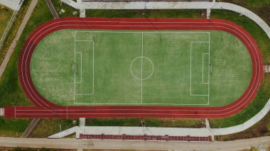 Yaz aylarında futbol ve koşu için spor stadyumu. Bir kuadkopter ile yeşil alanın üst görünümü