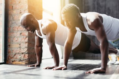 Pilates eğitmeni Afrikalı Amerikalı siyahi öğrencilerine şınav çekmeyi ve kas yapmayı öğretiyor..