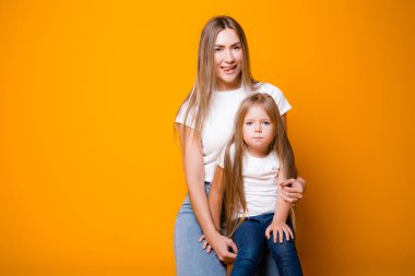 Turuncu arka planda anne ve mutlu kız. Aile ve annelik kavramı