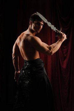 Gölgelerin içinden seksi highlander adam görünüyor