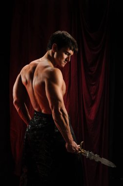 Gölgelerin içinden seksi highlander adam görünüyor