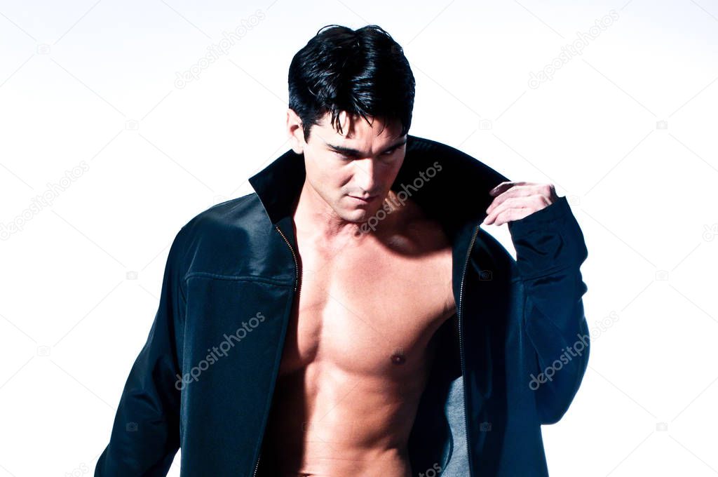The sexy man is wearing jeans and a black jacket.