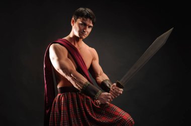 yakışıklı highlander parlak bir kılıç tutan