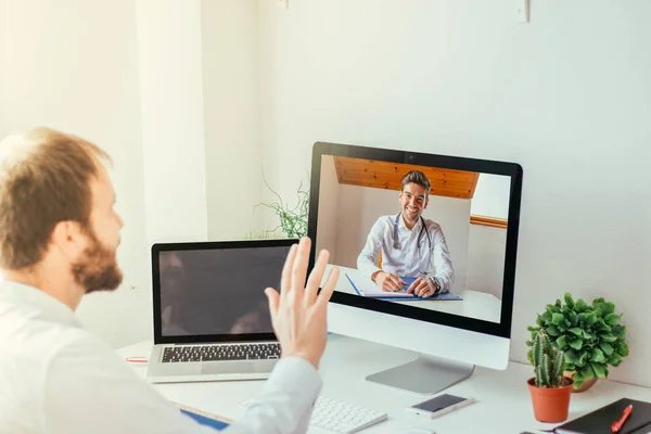 Evde doktorla görüntülü görüşme yapan bir adam.