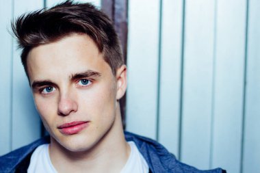 Mavi gözlü ve metal kapılı çekici genç adamın portresi. Boşluğu kopyala.