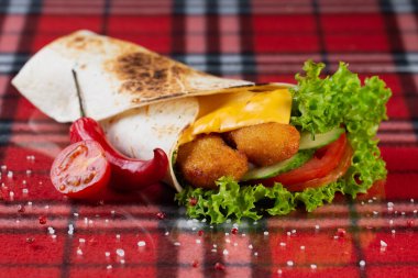 Tavuk nugget, taze sebze, peynir, kırmızı biber ve kiraz domatesli dürüm.