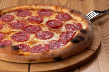 Tahta üzerinde sağlıklı İtalyan pizzası. Salamlı peynirli pizza.