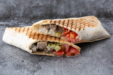 Domatesli domuz eti ve salatalık turşusu. Taş tabakta kızarmış pita ekmeği.