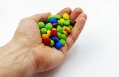 Uzamış ellerde, bir avuç lezzetli, yuvarlak, rahatlık, neşe, mutluluk hormonu için çikolatalar. Tatlı aşıkları için tedavi, tatlıya düşkünlük. Tatlı hayat..