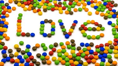 Aşk kelimesi yuvarlak şekerlerin arka planında yer alır. Yandan manzara..