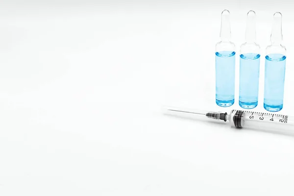 一个注射器和三个玻璃瓶的疫苗 蓝色的白色背景和标签的空间 该药用于预防 免疫和治疗头孢病毒感染 — 图库照片