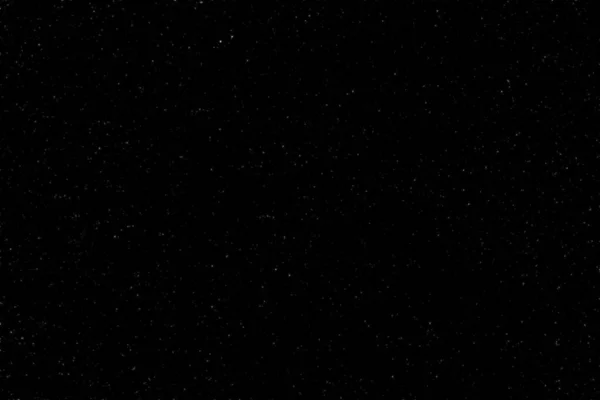 The spring dark, night sky was covered with a lot of stars with a place for the inscription. Real photo. You can use it for drawing on a material, marble tiles, or texture.