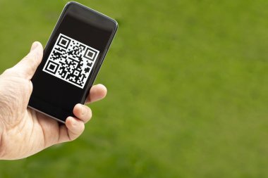 Yeşil arka planda QR kodu olan bir telefon. Modern elektronik, kablosuz belge yönetimi kavramı.