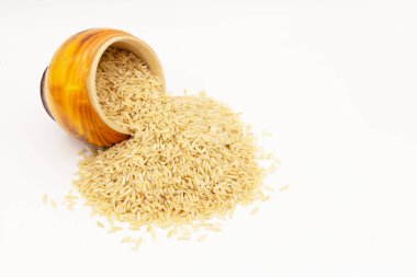 Uzun tahıllı kahverengi pirinç devrilmiş ahşap bir tencereden beyaz bir masaya döküldü..