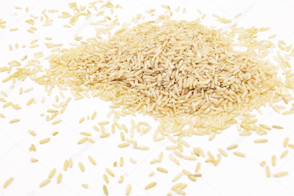Close-up of a pile of long-grain brown rice on a white background, a table in the laboratory for analysis or examination.