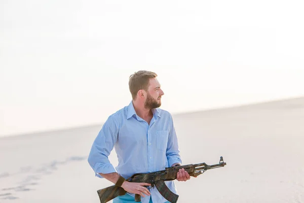 男立ちパーペンシャル砂漠シャツカラシニコフ兵器機銃日没白砂バルカン — ストック写真