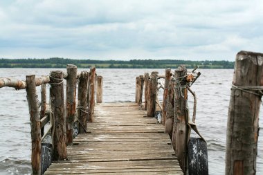 Bulutlu havada Volga Nehri 'ne bakan renkli ahşap iskele. Rusya