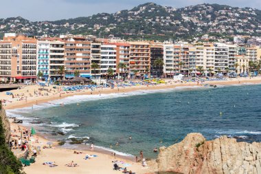 İspanya 'nın Lloret de Mar şehrinde birçok otel ve sahil kasabası vardır. İnsanlar sahilde dinlenir, banyo yapar, yüzer ve güneşlenir.