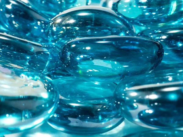Pierres de verre translucides bleues avec des reflets blancs sur un fond blanc — Photo