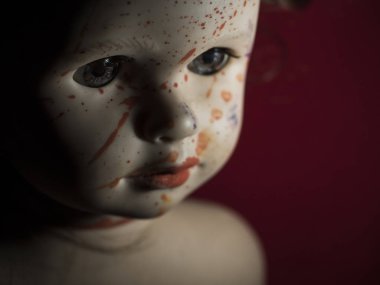 Alacakaranlıkta kırmızı bir arka planda kanlı bebeklerin yakın çekimi.