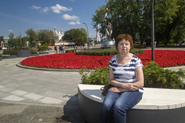 Señora Sentada Sobre Una Mesa Sobre Fondo Una Cama Flores — Foto de Stock