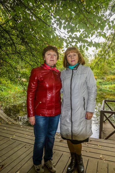 Dos Señoras Paran Puente Madera Sobre Fondo Estanque Árboles — Foto de Stock