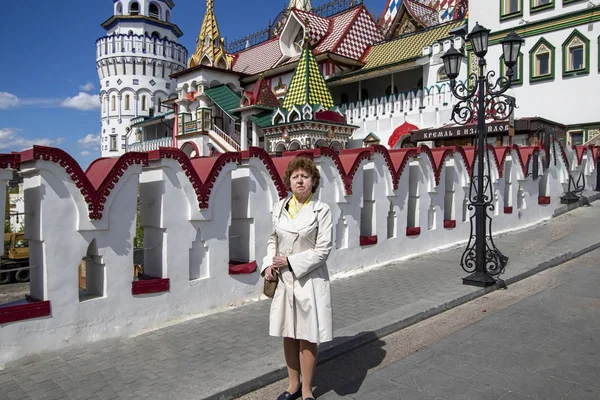Izmailovsky Kremlin 'in arka planında el çantası olan beyaz önlüklü bir bayan.