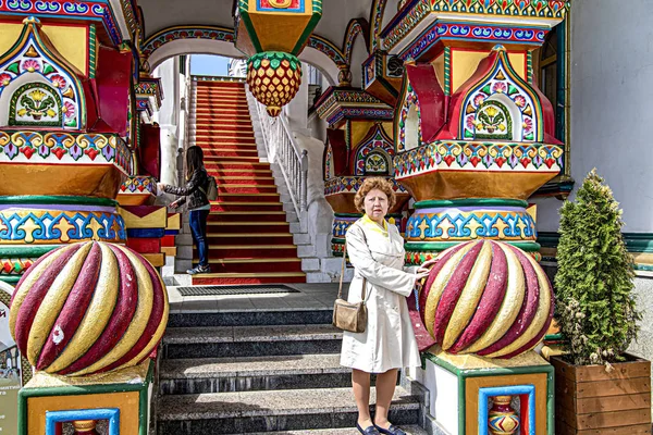 Parktaki dekoratif baloların arka planında beyaz pelerinli bir kadın.