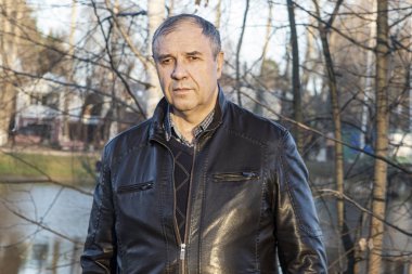 Sonbahar. Şehrin arka planında deri ceketli bir adam.