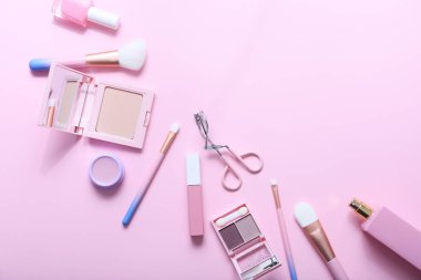 Pembe bir arka plan üzerinde dekoratif makyaj ürünleri ile düz yatıyordu kompozisyon