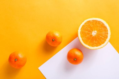 Parlak arka planda dilimlenmiş portakal ve mandalina.