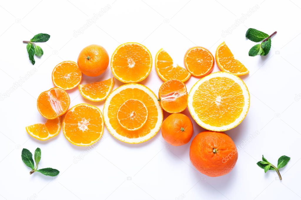 Group of sliced oranges and tangerines with mint leaves on white background