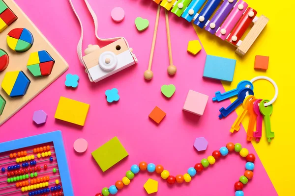 Színes gyerekjátékok rózsaszín háttérrel. Felülnézet, lapos fektetés. — Stock Fotó