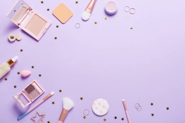 Set of professional decorative cosmetics, makeup tools and accessory on lilac colored background. Beauty, fashion and shopping concept. Flat lay composition, top view